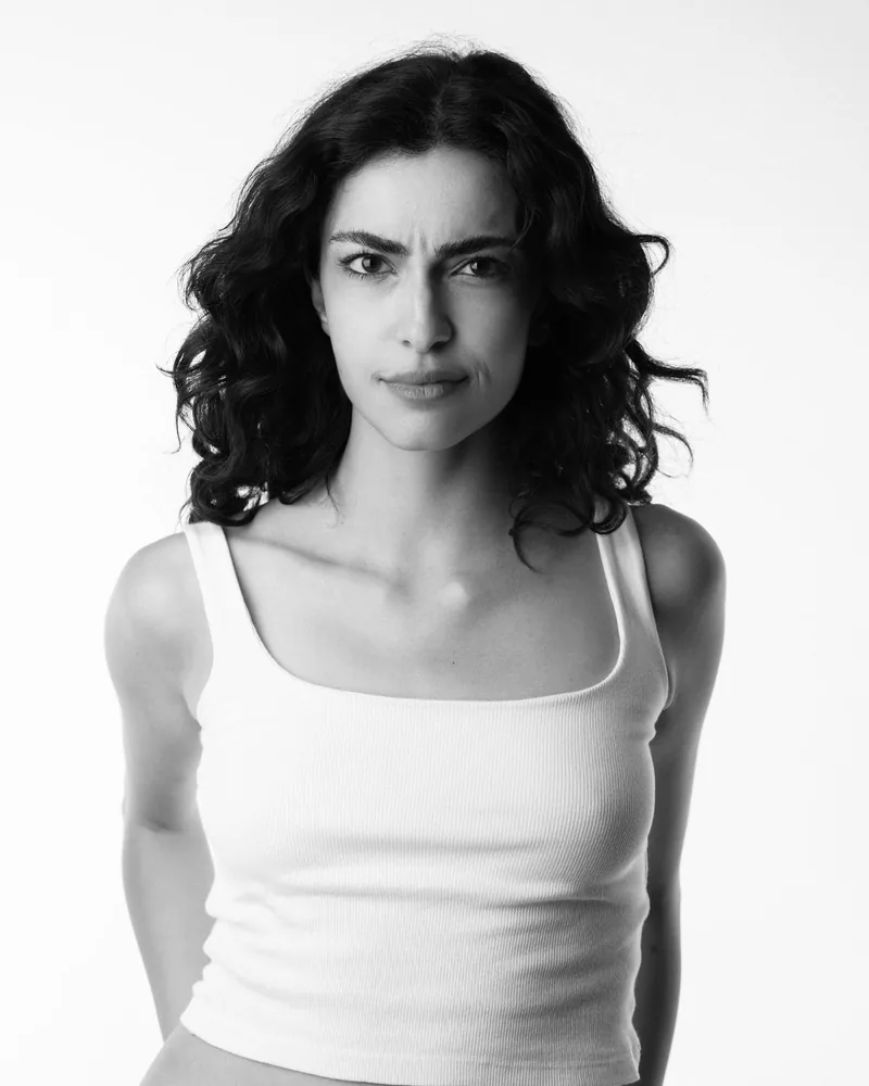 Elvin Köse, black and white studio portrait in a white vest