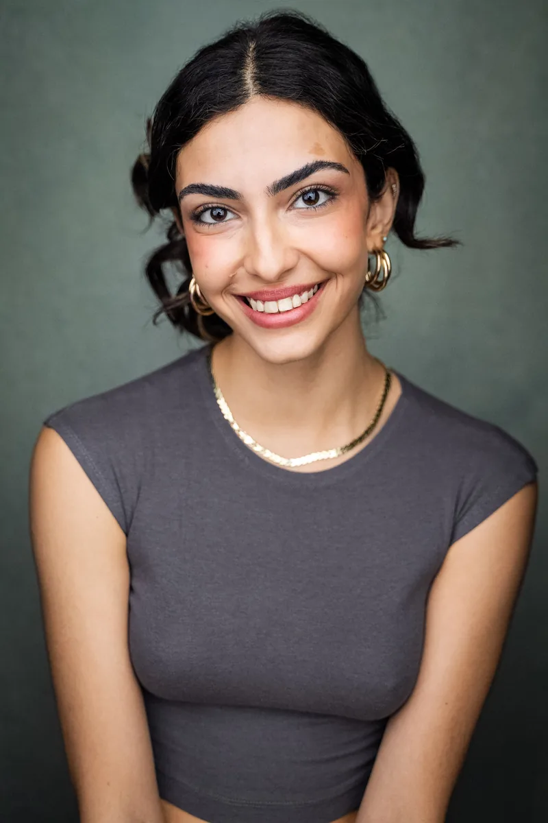 Elvin Köse, headshot by YellowBellyPhoto, smiling, sage backdrop